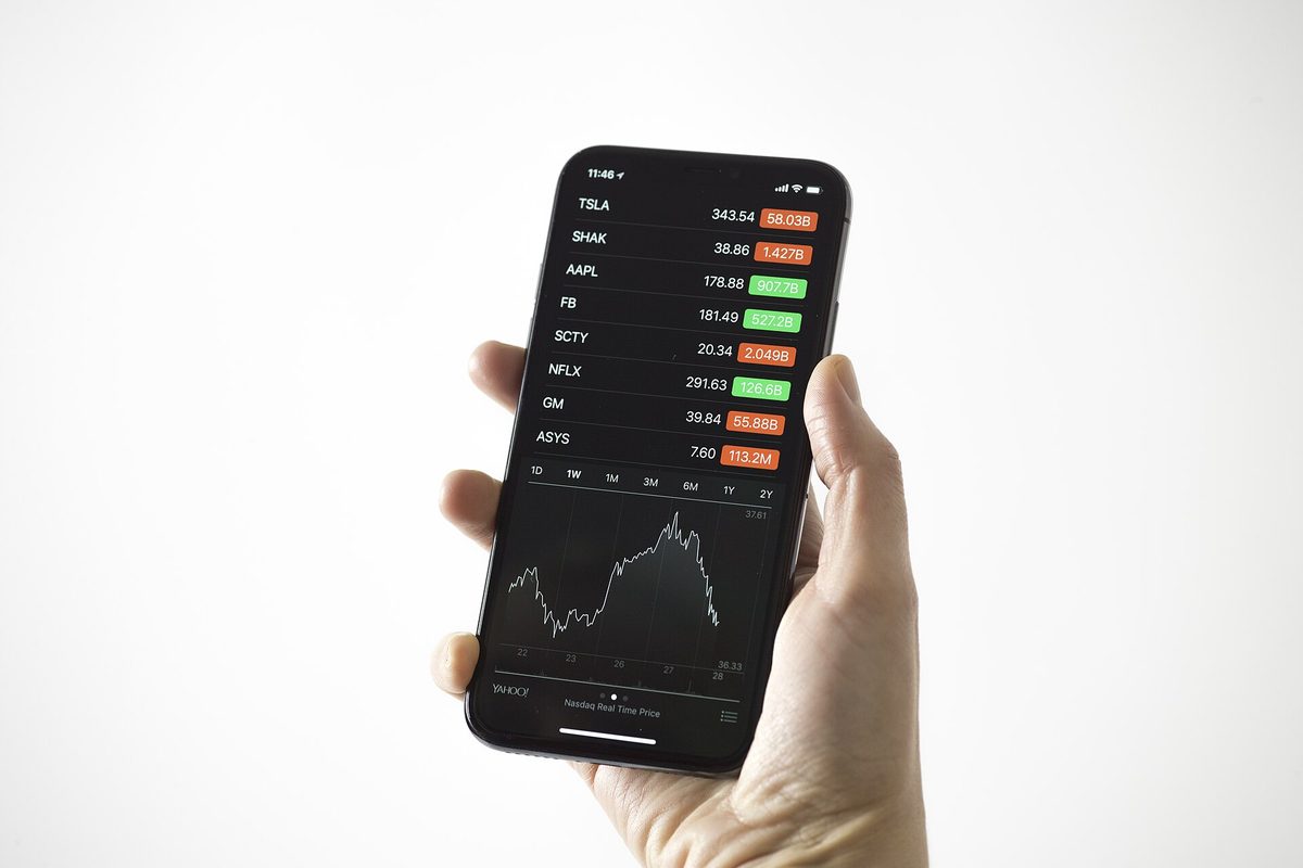 A handheld screen displaying a list of securities and a price chart